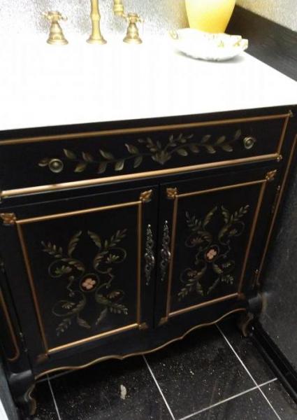 Black and gold bathroom vanity cabinet remodel with white countertop.